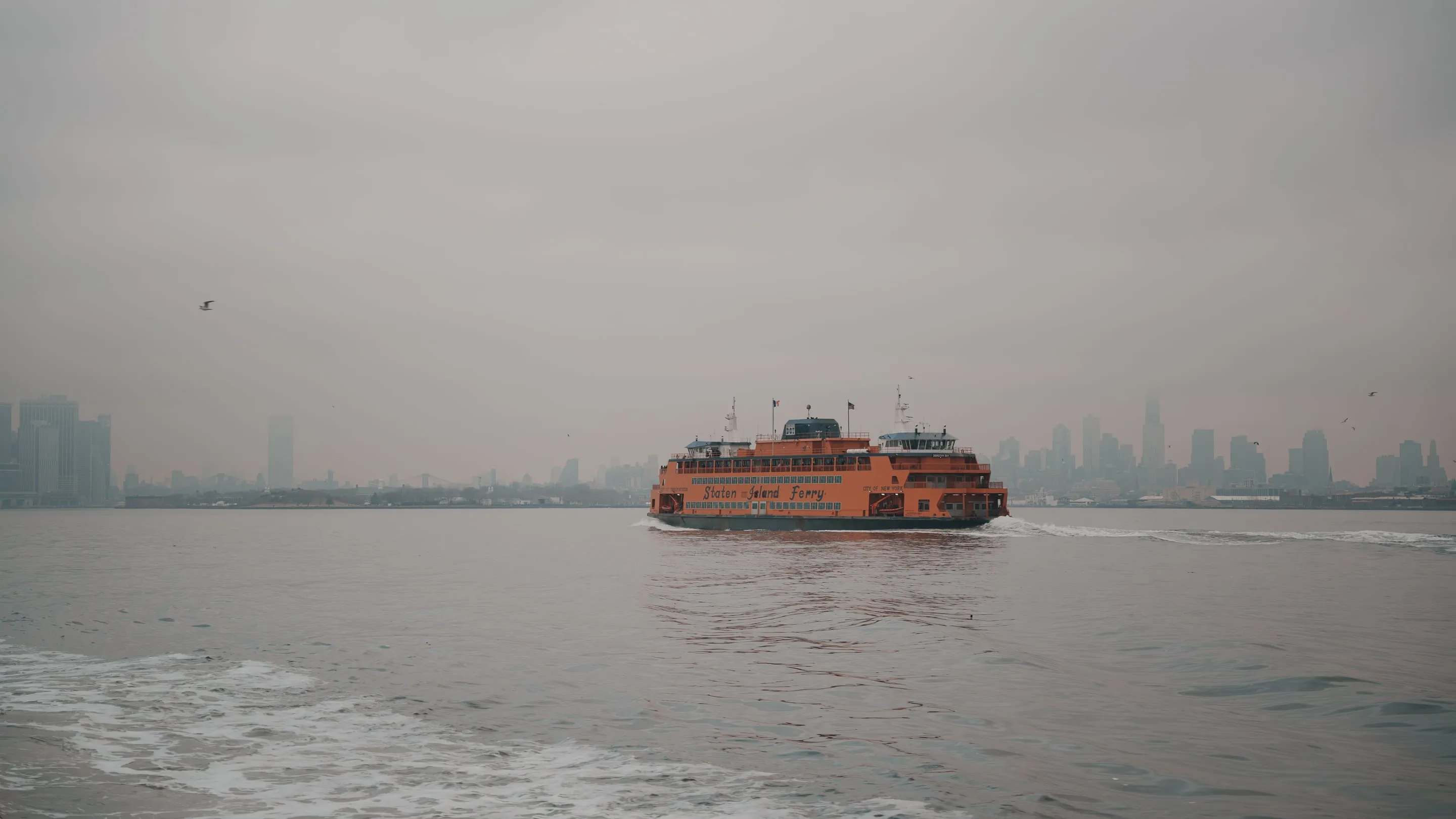 The Staten Island Ferry crossing New York Harbor with the Lower Manhattan skyline behind it